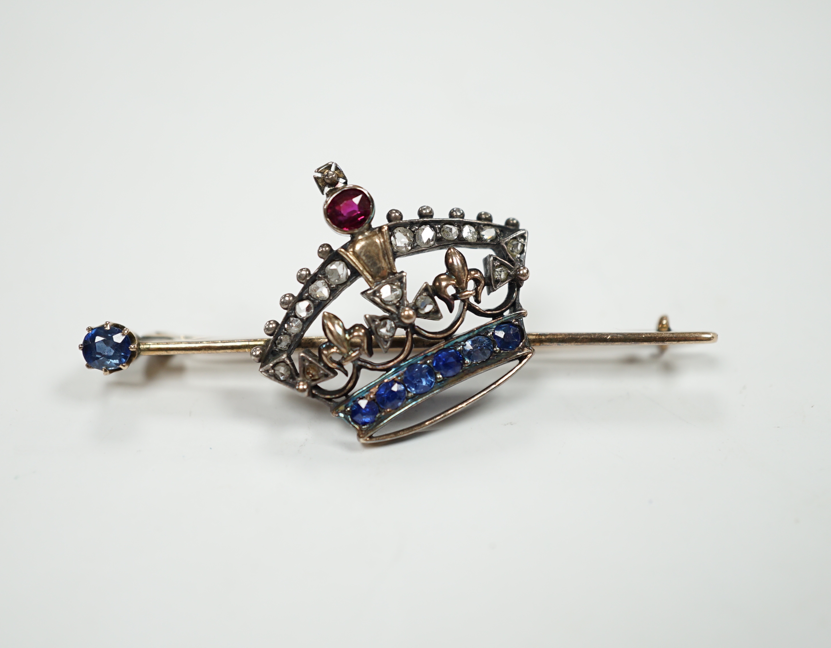 An Edwardian yellow metal, ruby, sapphire and rose cut diamond set coronet bar brooch, 50mm, gross weight 5.8 grams.